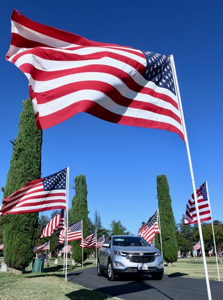 Drivers navigate the roadway past flags.